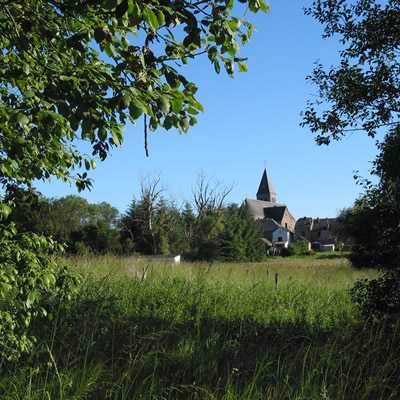 Photo du village d'Herbeumont encadré par le feuillage d'un arbre